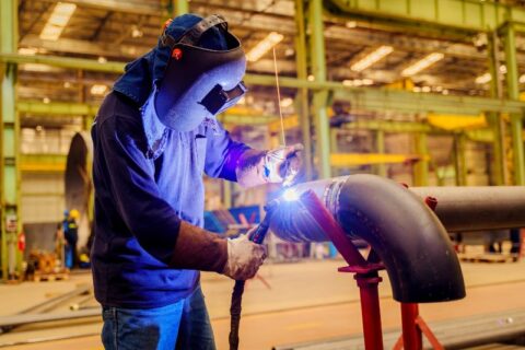 An industrial worker is performing ASME code welding on high-pressure piping in Chicago, IL