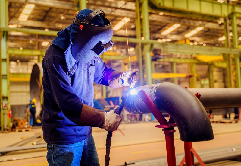 An industrial worker is performing ASME code welding on high-pressure piping in Chicago, IL