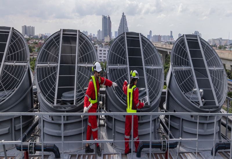 Technicians inspecting large industrial ventilation systems on a rooftop facility in Export, PA